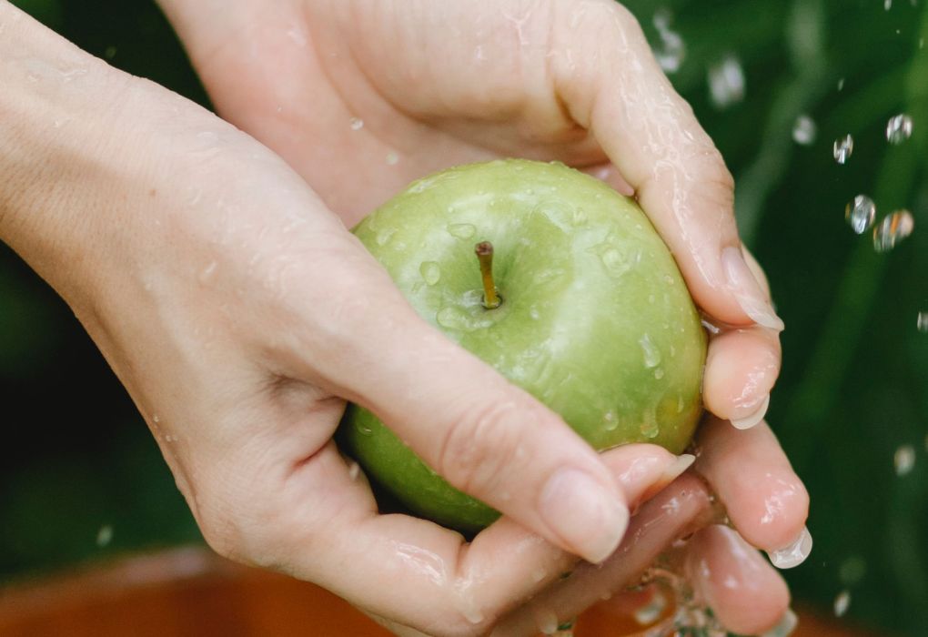 Frau hält ein nasser Apfel in der Hand