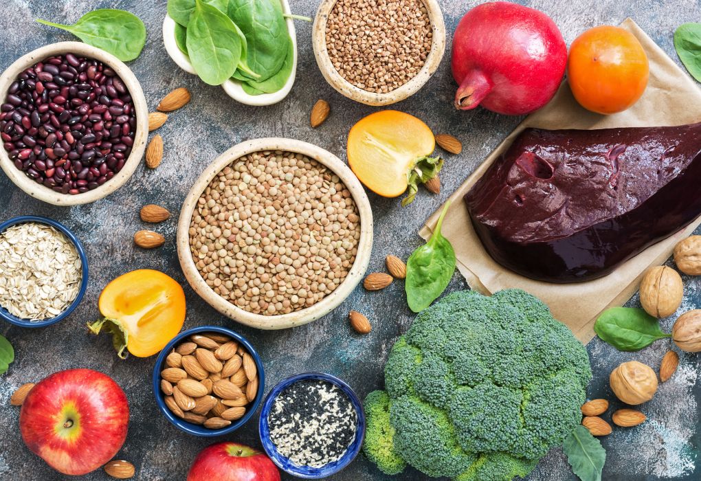 Teller mit Hülsenfrüchten, Gemüse und Obst, reich an Eisen.