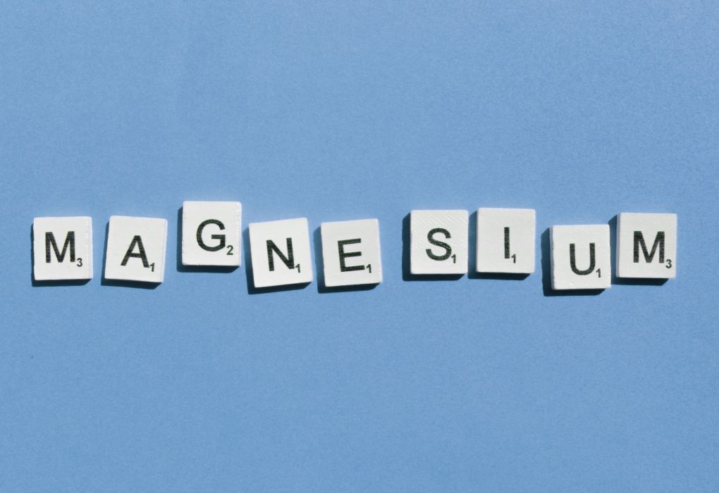 Scrabble-Buchstaben bilden das Wort Magnesium auf blauem Hintergrund
