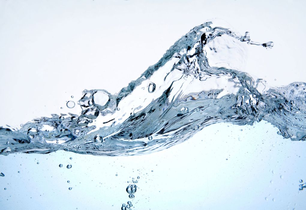 Klarer Wasserstrahl spritzt dynamisch in die Höhe auf weißem Hintergrund