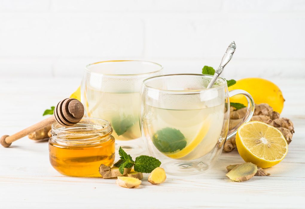Zwei Gläser Ingwer-Zitronen-Tee mit Honig und frischer Minze