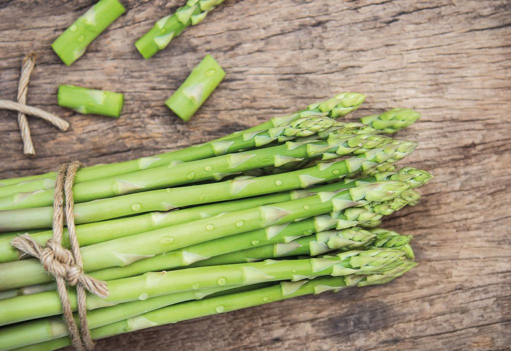 Frischer grüner Spargel auf einem Holzbrett