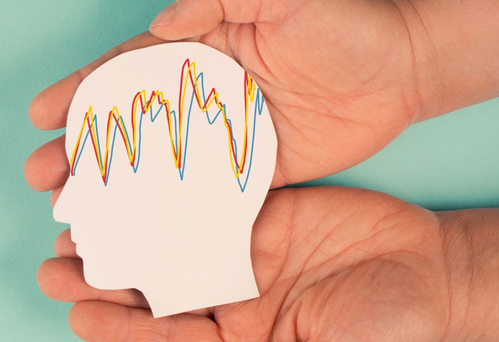 Hand hält ein Kopfmodell mit gezackten Linien als Symbol für epileptische Anfälle