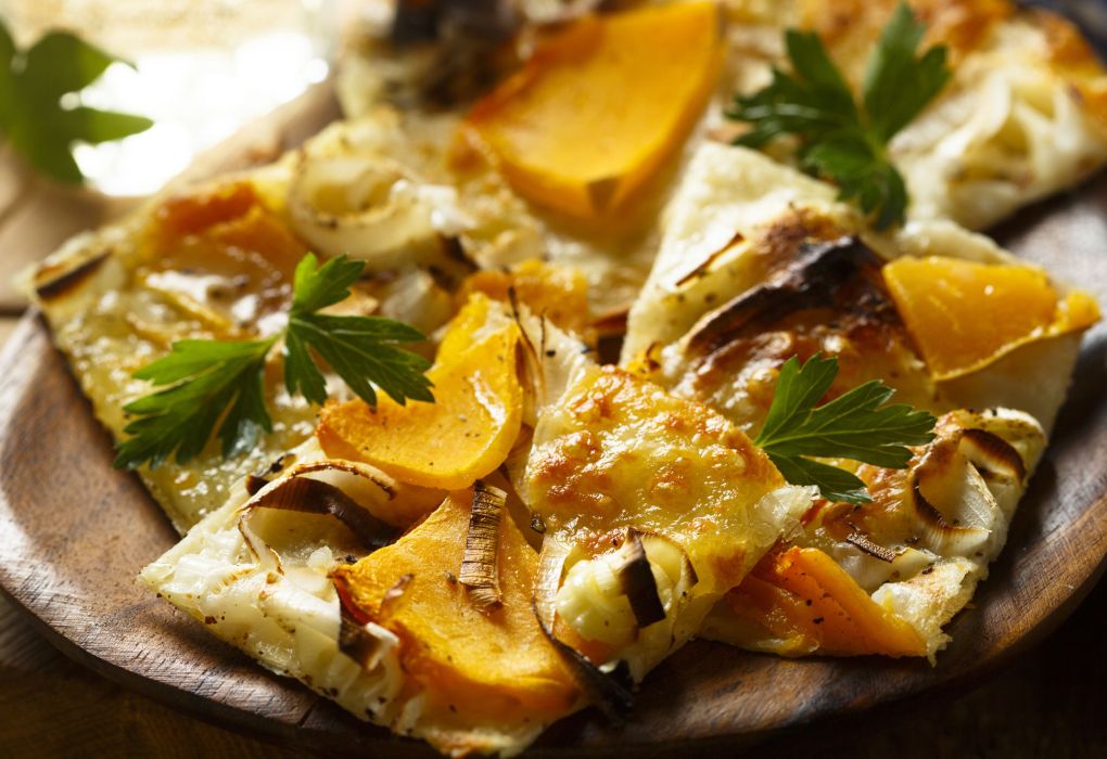 Frisch gebackener Flammkuchen mit Kürbis und Kräutern.