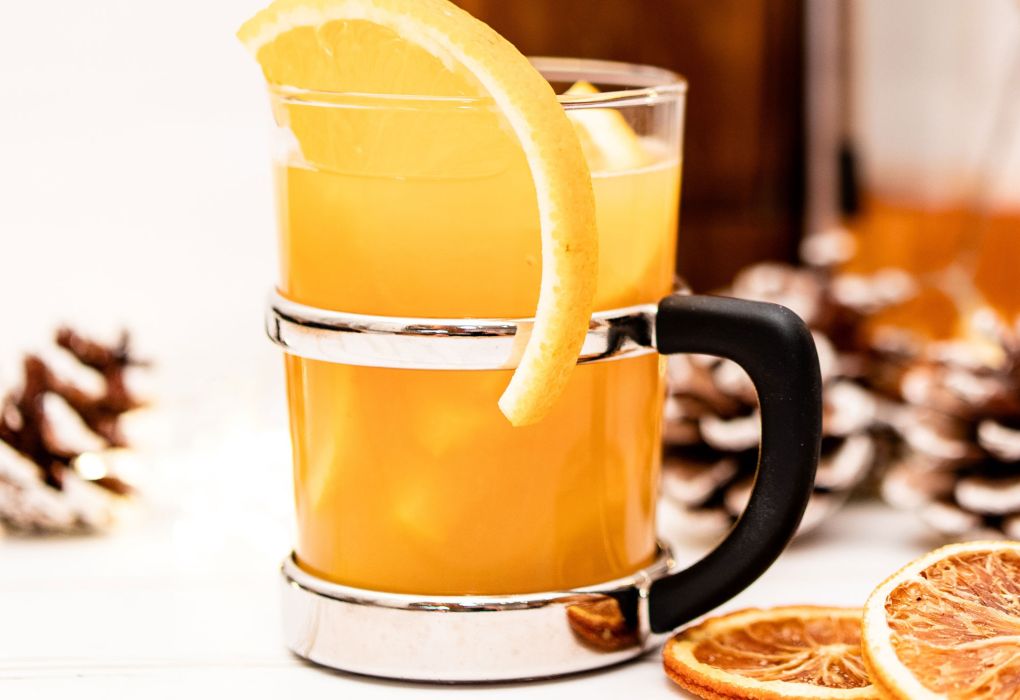 Glas mit Punsch und Orangenscheibe, winterliche Stimmung.