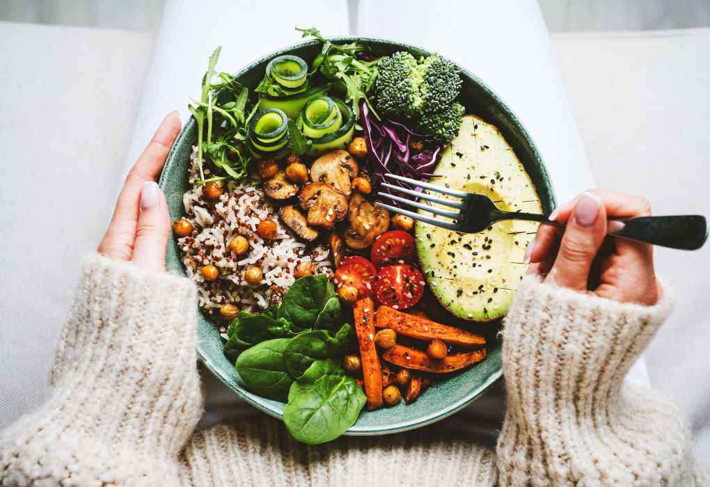 Schüssel mit buntem Gemüse, Avocado, Reis und Salat