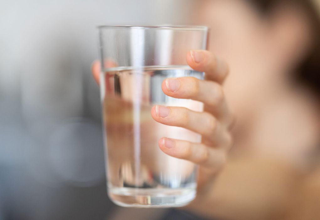 Frau hält ein Glas Wasser in der Hand