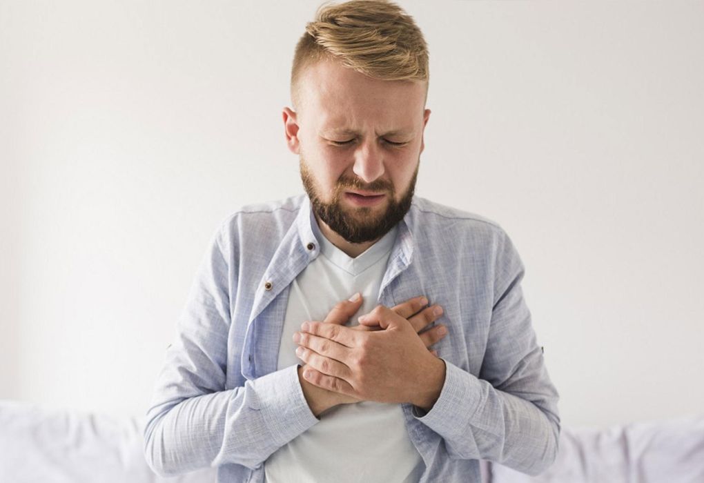 Mann hält sich die Brust wegen brennendem Schmerz