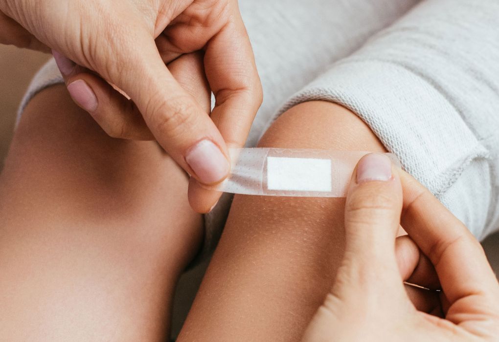 Hände kleben ein Pflaster auf die Haut,
