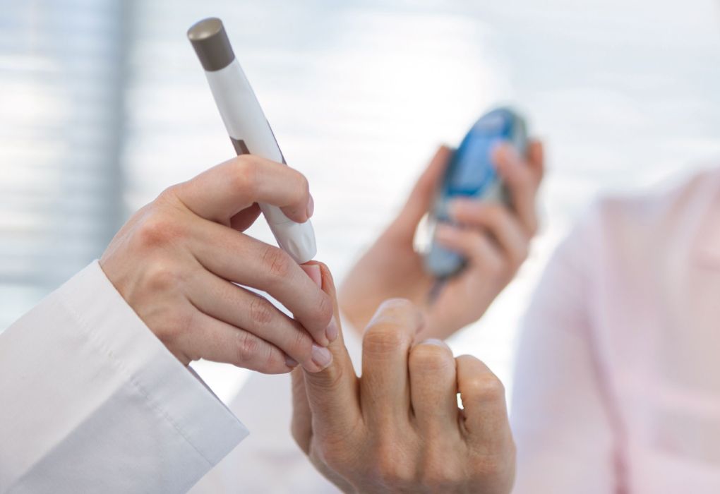 Person misst Blutzuckerwert am Finger mit einem modernen Messgerät