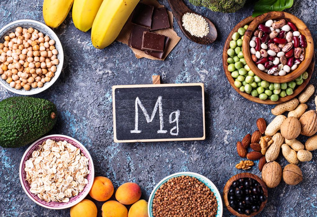 Lebensmittel wie Nüsse, Samen, Bananen und Gemüse rund um eine Tafel mit der Aufschrift „Mg“