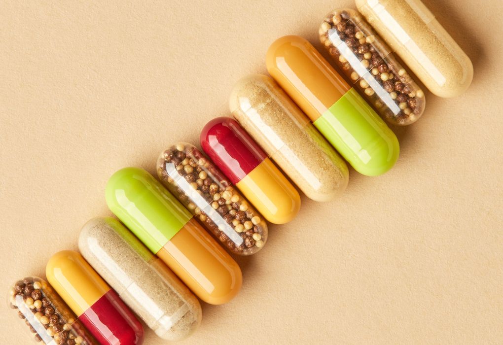 Kapseln mit Nahrungsergänzungsmittel auf beigefarbenem Hintergrund