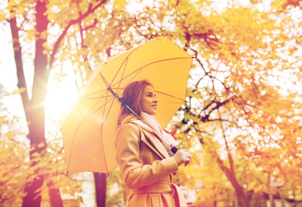 Frau mit Regenschirm im herbstlichen Wald