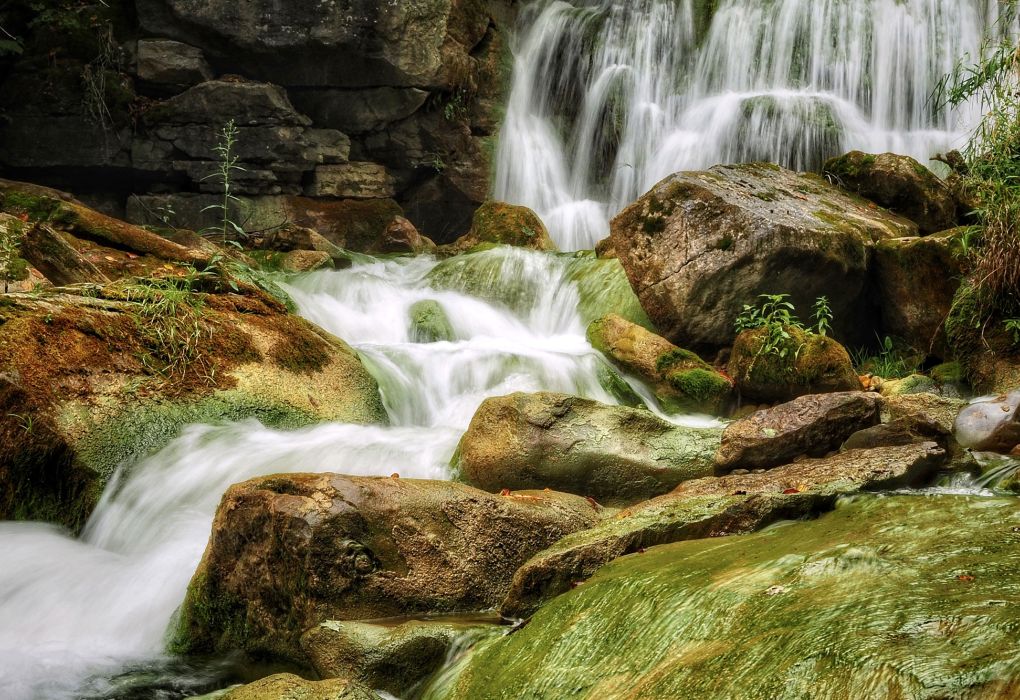 Wasserfall fließt über moosbewachsene Steine