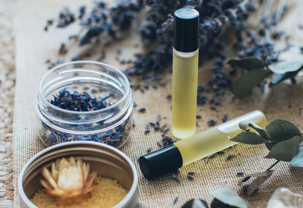 Lavendelblüten und ätherisches Öl auf hellem Hintergrund