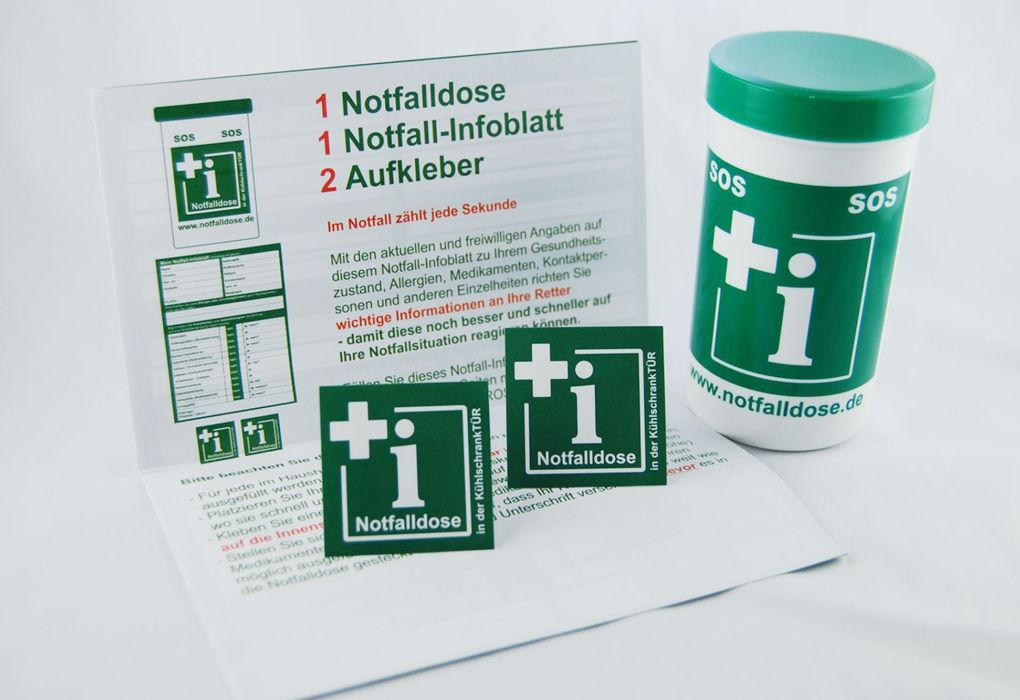 Grüne Notfalldose mit Symbolen und Aufschrift, medizinische Vorsorge.