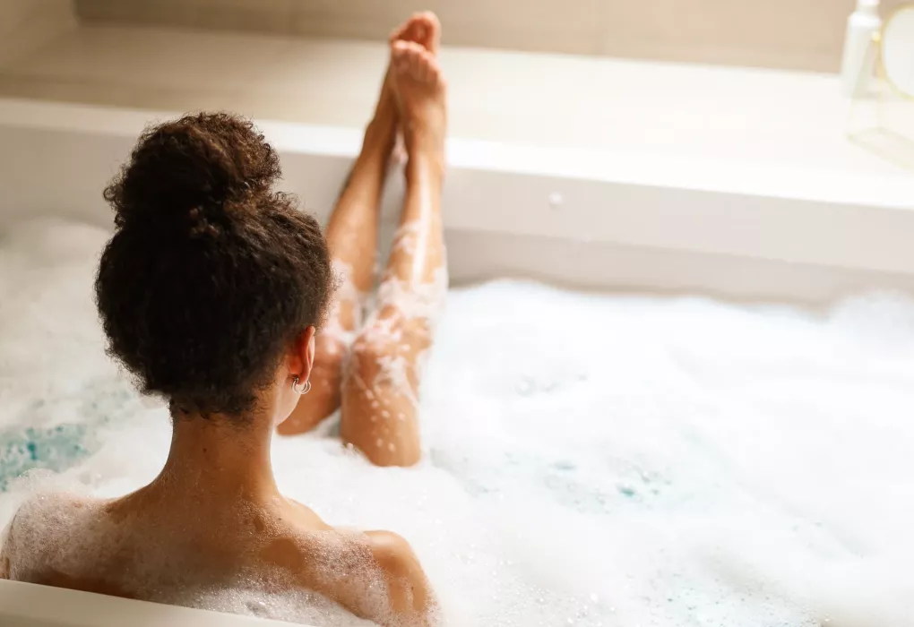 Frau sitzt im warmen Schaumbad