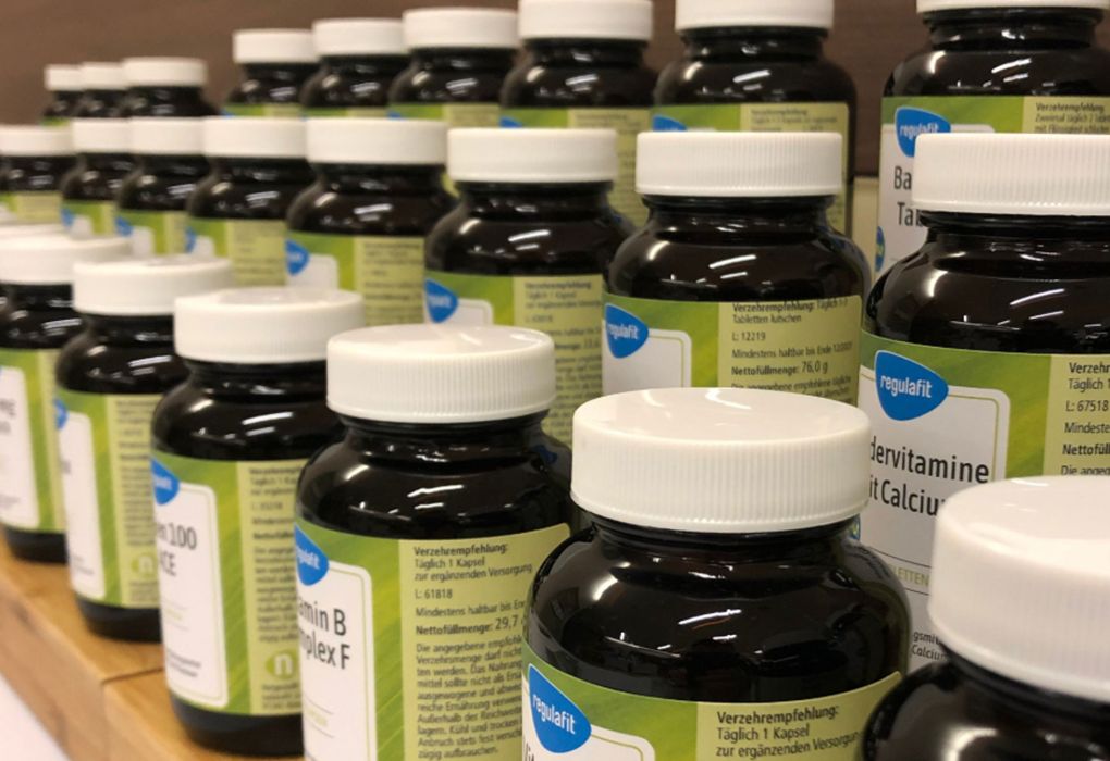 Mehrere braune Arzneiflaschen stehen dicht aneinandergereiht im Verkaufsregal