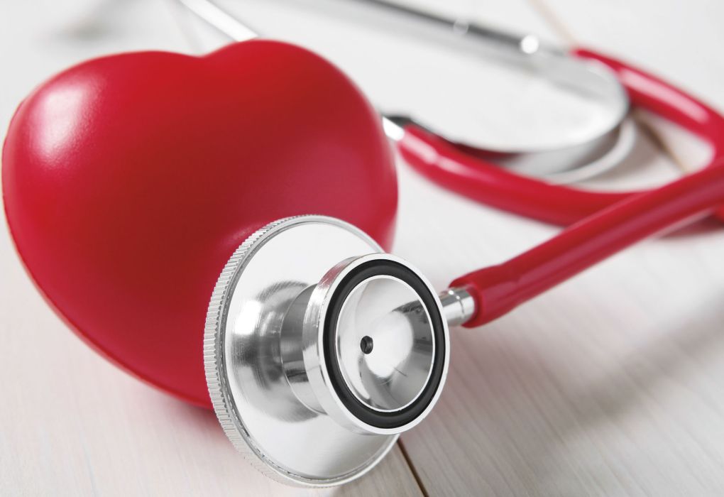 Rotes Herzmodell mit Stethoskop auf weißem Hintergrund