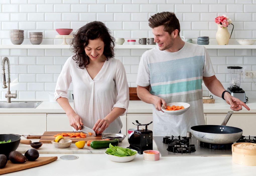 Paar kocht gemeinsam in moderner Küche.