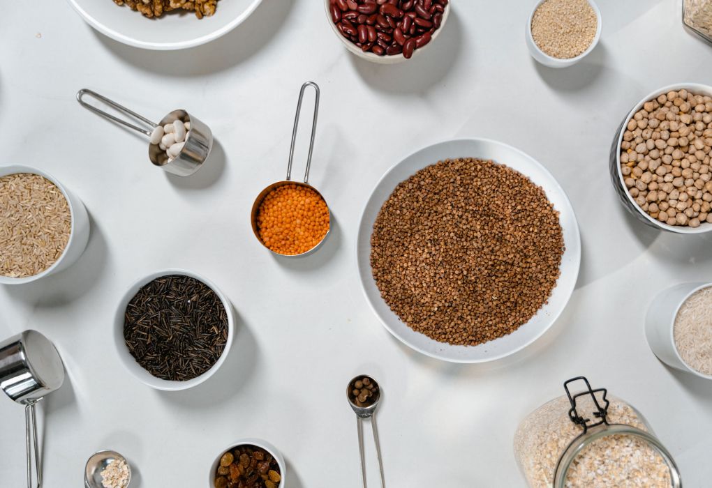 Schalen mit Vollkorn, Nüssen, Samen und Hülsenfrüchten als Ballaststoffquellen