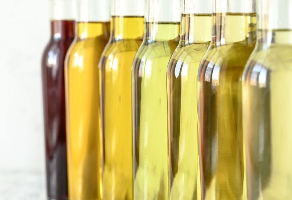 Mehrere Glasflaschen mit goldgelbem Öl in einer Reihe