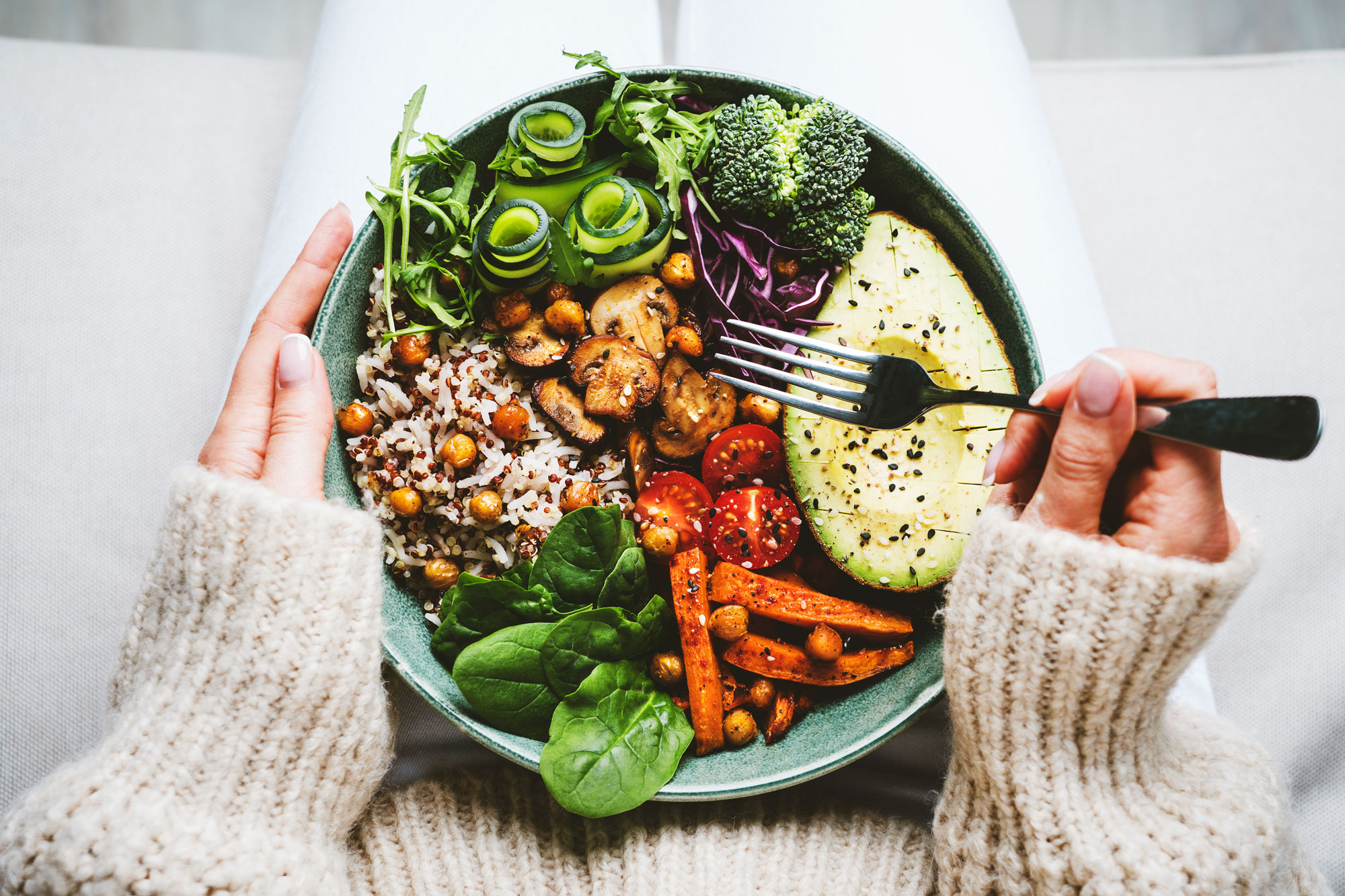 Schüssel mit buntem Gemüse, Avocado, Reis und Salat