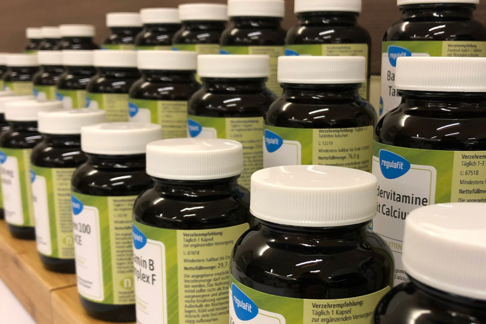 Mehrere braune Arzneiflaschen stehen dicht aneinandergereiht im Verkaufsregal