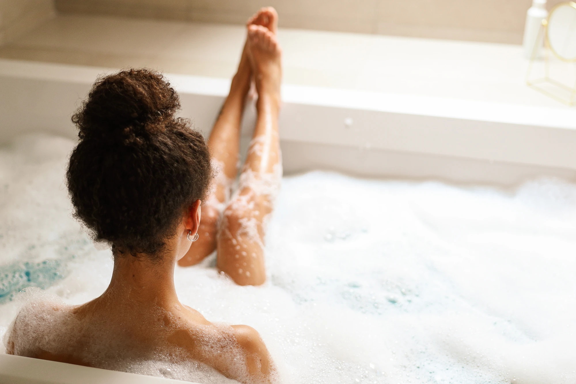 Frau sitzt im warmen Schaumbad
