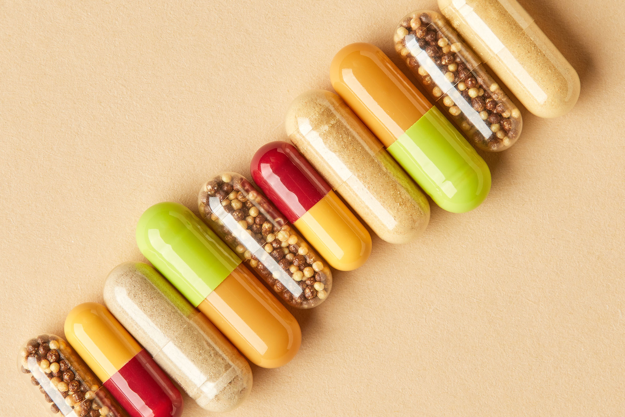 Kapseln mit Nahrungsergänzungsmittel auf beigefarbenem Hintergrund