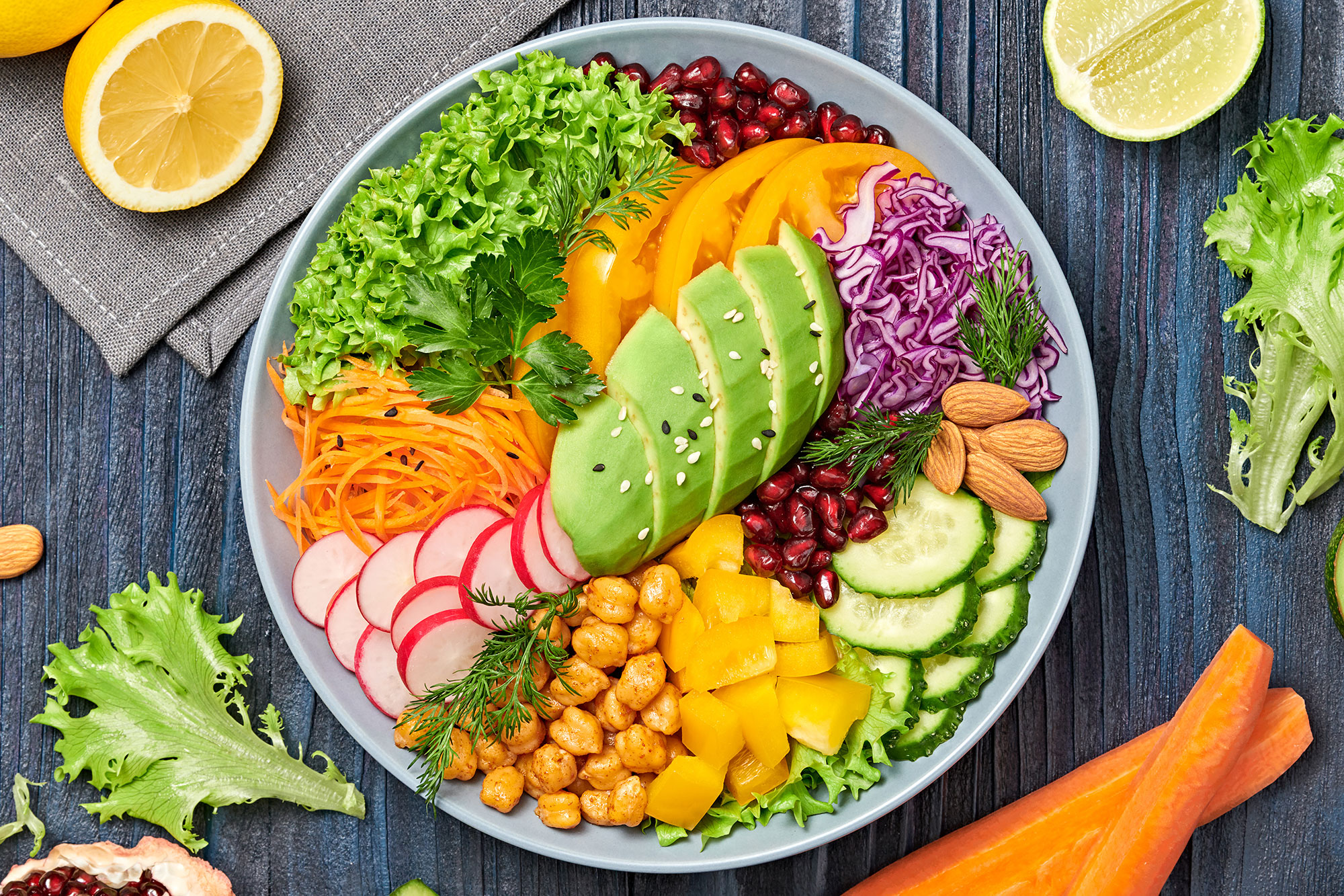 Schale mit verschiedenem Gemüse, Kirchenerbsen und Avocado von oben fotografiert.