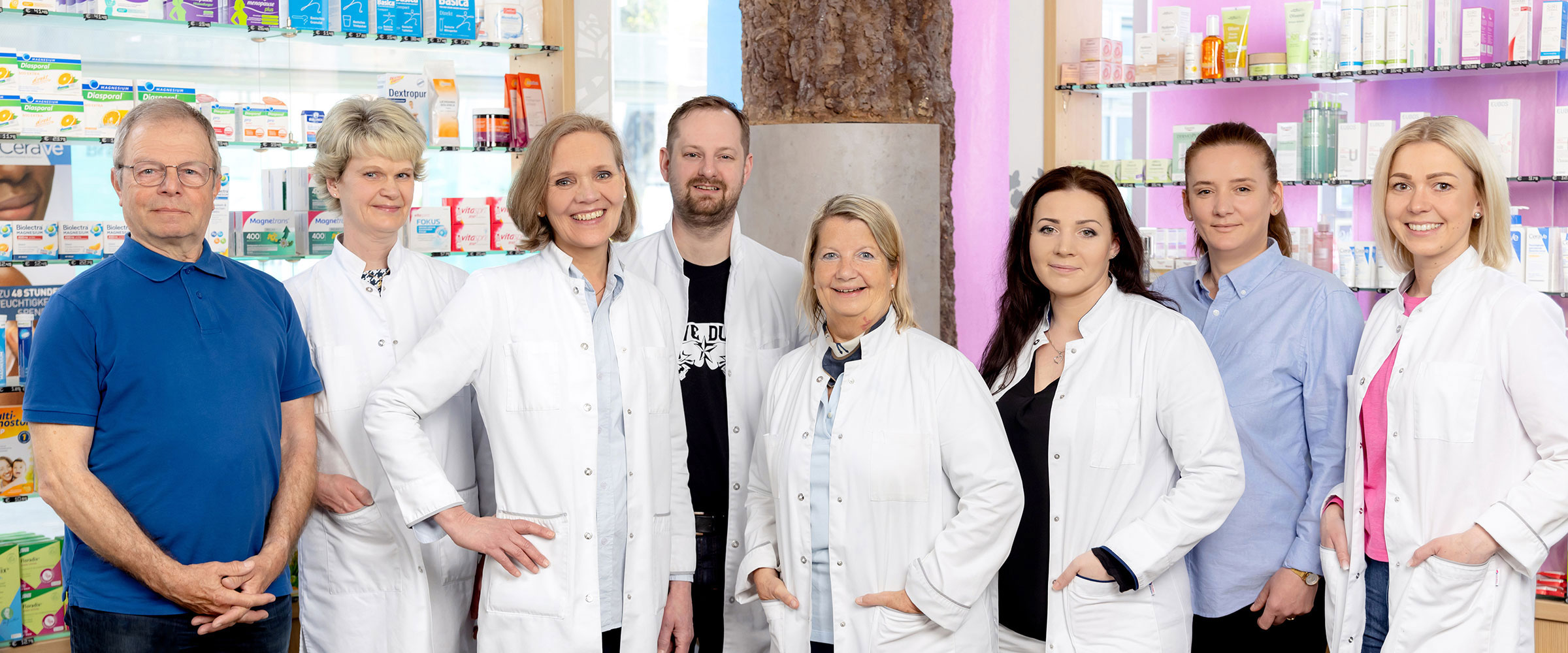 Das Team der Apotheke im Storchenhof steht in der Apotheke und lächelt freundlich